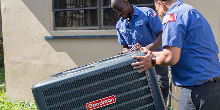 Service technicians moving new air conditioner and heater onto property