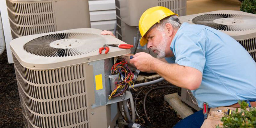 Service technician working on replacing wiring for air conditioner